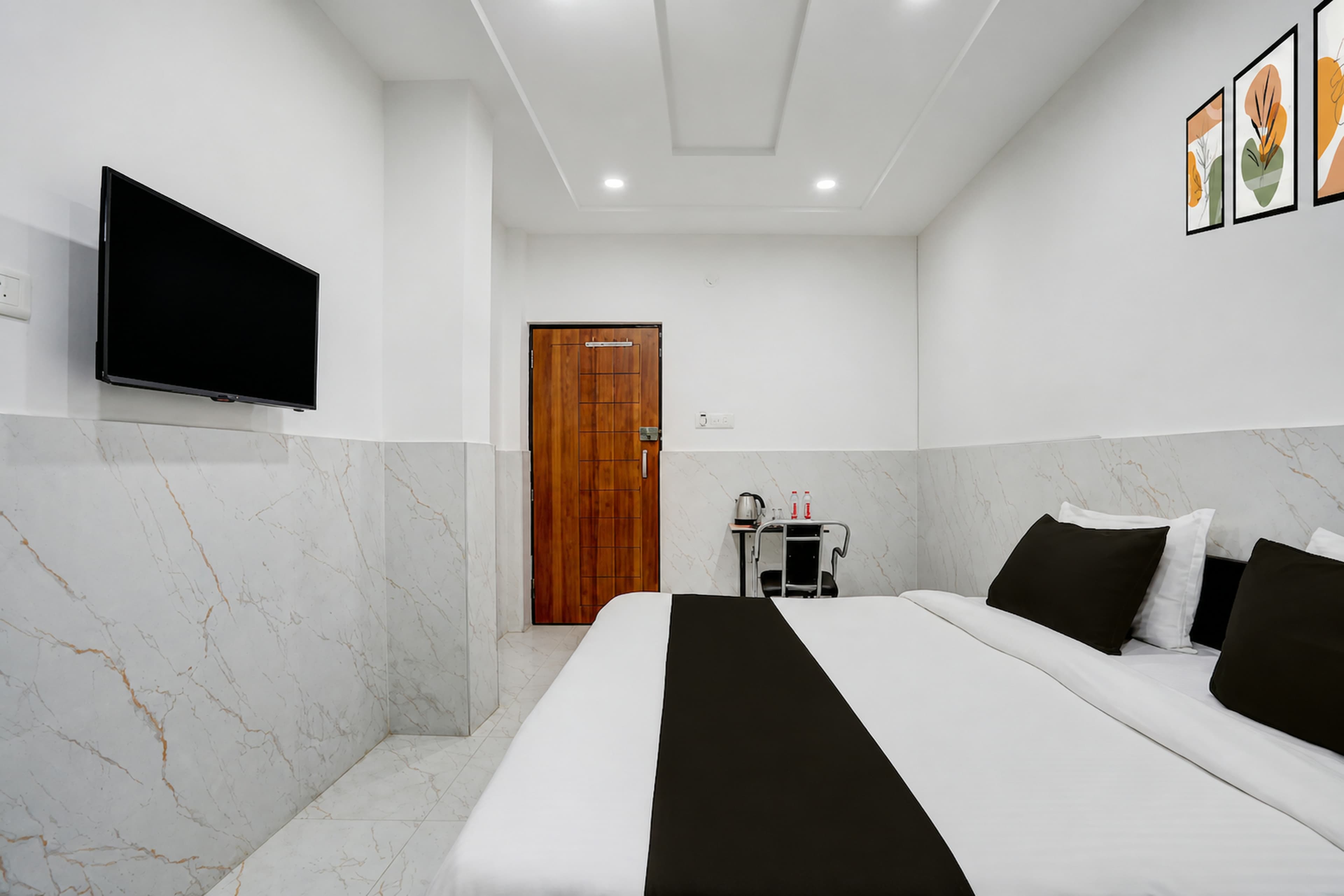 Classic room with a made-up double bed and wall-mounted TV